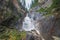 Waterfall in the mountains among the rocks on the Shinok river taiga and forest