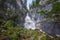Waterfall in the mountains among the rocks on the Shinok river taiga and forest