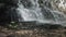 A waterfall in the mountains, water pours from the rocks, splashes from the waterfall, water splashed over stones in nature