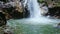 Waterfall from Pond Rocks to Foamy Stream Top among Green Rocks