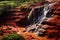 Waterfall in red sandstone canyon with green grass and trees, The famous Red Dirt Falls, a cascading waterfall of fresh water over
