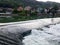 Waterfall on the river Vrbas in Novoselija, near Banja Luka. Landscape with river, village and forested mountains during a sunny