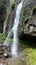 A waterfall on a rock and people