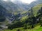 Waterfall runlets into alpine mountain valley summer season landscape