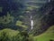 Waterfall running through Europe road side mountain. Lush nature