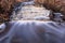 Waterfall in several stages and fallen leaves