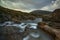 Waterfall with silky water towards mountain with cloudy sky- Fairy Pools - Skye Island - Scotland - Uk