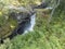 Waterfall Slettafossen at Verma with viewpoint platform deep narrow Rauma river canyon at Romsdalen valley with rocks