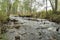 Waterfall on a small river flowing through the autumn forest.