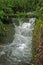 Waterfall of a small stream in channel through the forest in South America Ecuador