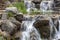 Waterfall between stone boulders, landscape design element