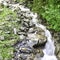 Waterfall through the stones and grass