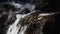 Waterfall stream of rapid water over rocky stones