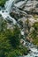 Waterfall on summer day in nature. Rapid water stream falling from rocks against blue sky on sunny summer day in