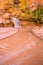 Waterfall to shallow river under golden cottonwood trees