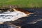 Waterfall on the Tosno River with rapids and stony shore.  Sablino. Leningrad region. Russia