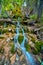 Waterfall trickling over rocks and moss in quaint forest scene