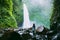 Waterfall in tropical jungle and alone woman. Waterfall in Bali