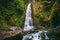 Waterfall in tropical jungle and alone woman. Waterfall in Bali