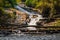 Waterfall in tropical jungle in Thailand, green yellow water