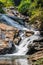 Waterfall in tropical jungle in Thailand, green yellow water sharp