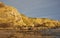 A waterfall tumbling down the golden sea cliffs at St Cyrus beach in Aberdeenshire