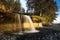 Waterfall under a cloudy blue sky in Sandcut Regional Park in Canada