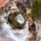 Waterfall water of a mountain lake under a blue sky in the clouds. sand beach. Tiny little planet 360