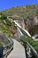 Waterfall with wooden boardwalk and rocks. Ezaro cascade, Xallas river. Dumbria, Spain.