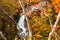 Waterfall in Yukawa River in the colorful foliage of autumn forest