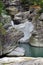 Waterfalls in a canyon. Green clear stream and rock formations