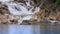 waterfalls of mountain stream flow into lake at foreground