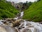 Waterfalls and picturesque meadows of Alps.