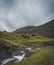 Waterfalls in the village of Saksun on the Faroe islands. No people around, traditional stone houses.