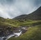 Waterfalls in the village of Saksun on the Faroe islands. No people around, traditional stone houses.