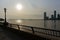 Waterfront and a Bright Sun at Battery Park in New York City with a view of the Jersey City Skyline along the Hudson River