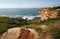 Waterfront lookout on hill with idyllic and amazing seaside landscape of bluff with shrubs, jagged coast with rocks, ocean horizon