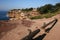 Waterfront lookout with trail wood barriers on hill with idyllic and amazing seaside landscape of bluff with shrubs, ocean horizon