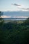 A waterfront small town cityscape under a beautiful cloudy sky seen through tree branches