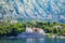 Waterfront of small town Dobrota along Bay of Kotor, Montenegro. View of Church of St Mathew, coastal villas, gardens and mountain