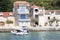 Waterfront stone houses by the sea and a rubber boat arriving to the dock, in Prvic island, Croatia