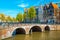 Waterfront with traditional dutch houses and old bridge, Amsterdam, Netherlands