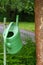 Watering can hanging on faucet, gardening, summer.