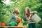 Watering flowers in garden. Kids planting flowers in pot. Children farmer in the farm with countryside background.