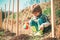 Watering flowers in garden. Little farmer with Shovel and watering can. Moments in the countryside. Child care plants