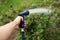 Watering green garden with outdoor hose. hand with hose sprinkle watering plants in the garden. watering lawn or plants