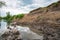 Watering place, traces of hoofs of cows and horses in the valley of river. Grazing livestock.