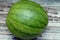 Watermelon (Citrullus lanatus) isolated on a wooden background, succulent fruit and vinelike plant of the gourd family