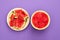 Watermelon cut in half and slices isolated in violet heliotrop background with copy space viewed from above