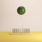 Watermelon floating above nail traps on yellow pastel background